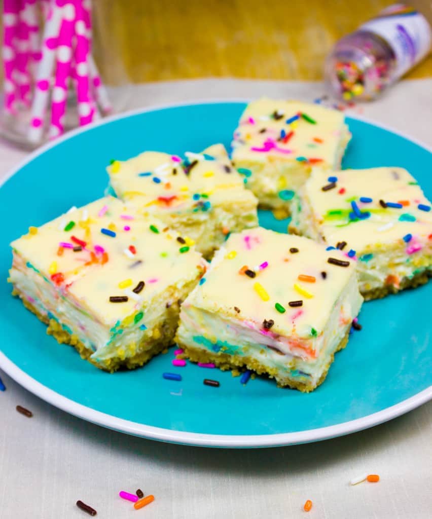sprinkle covered cheesecake squares on blue plate