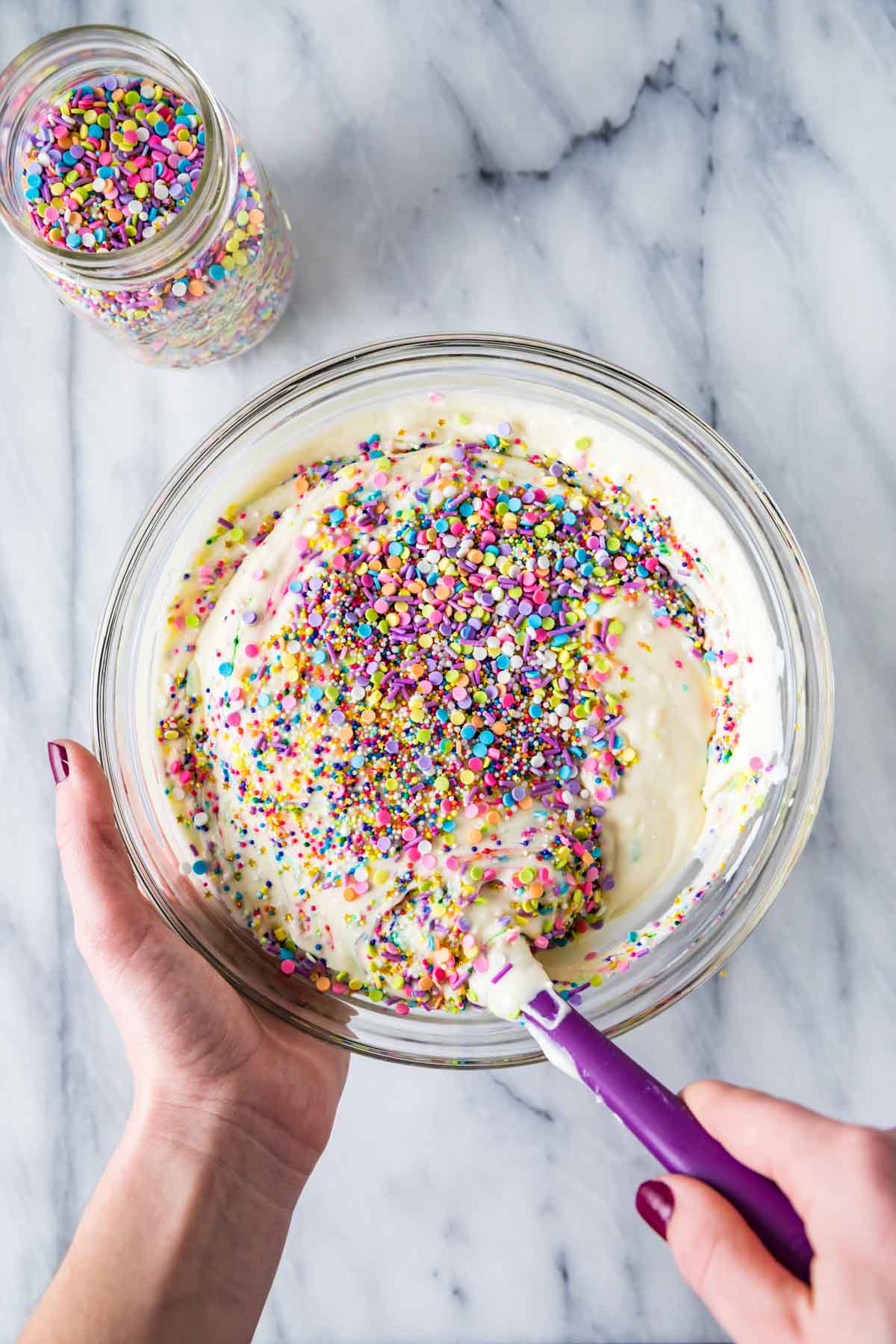 stirring sprinkles into a cheesecake batter