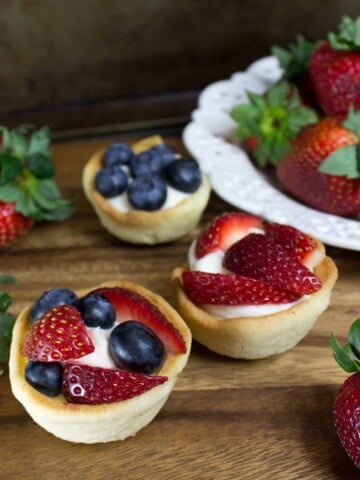 cookie cup filled with cheesecake and topped with berries