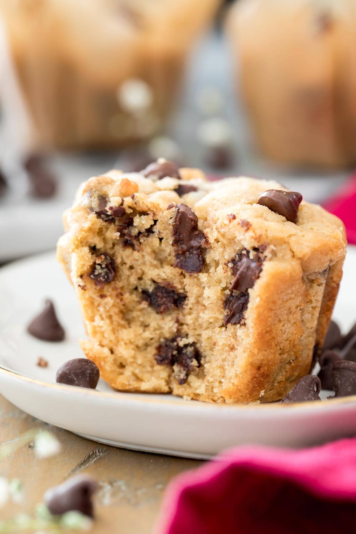 peanut butter muffin with a bite out of it on a white plate, showing off soft fluffy interior