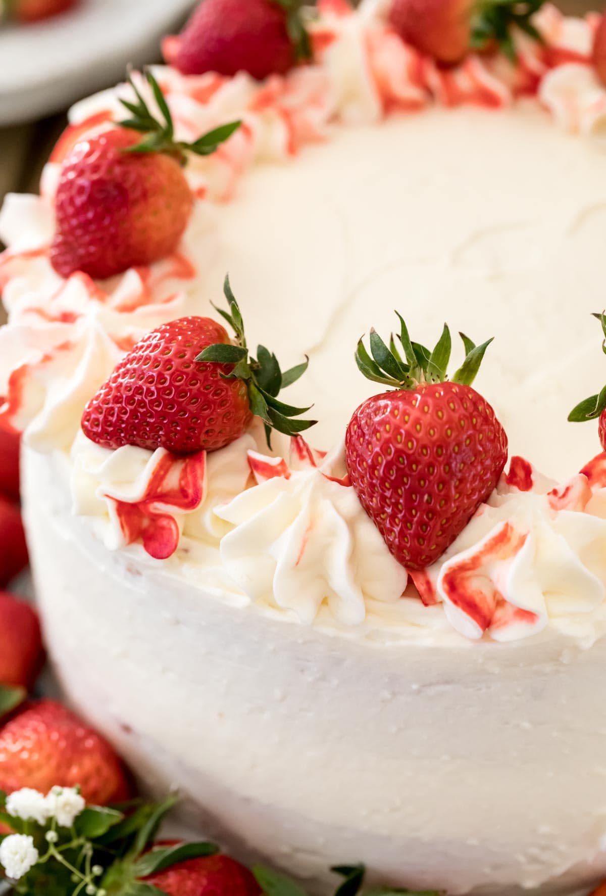 white iced cake with red strawberries