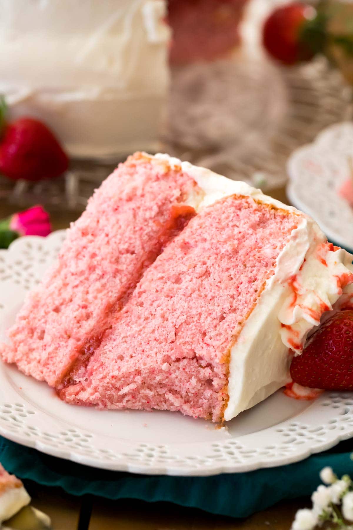 strawberry cake made from scratch on white plate. forkful missing to show soft and fluffy texture