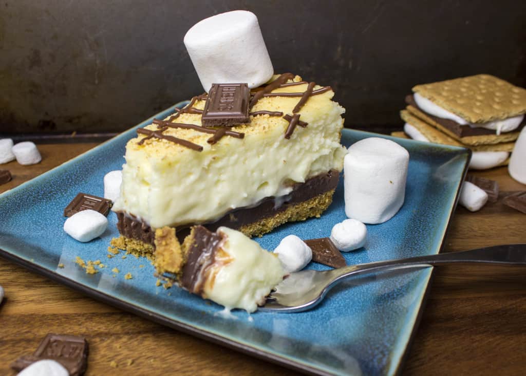 slice of S'mores Cheesecake on blue plate with fork