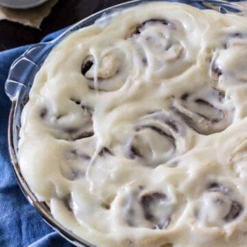 Iced cinnamon rolls in a glass pie dish