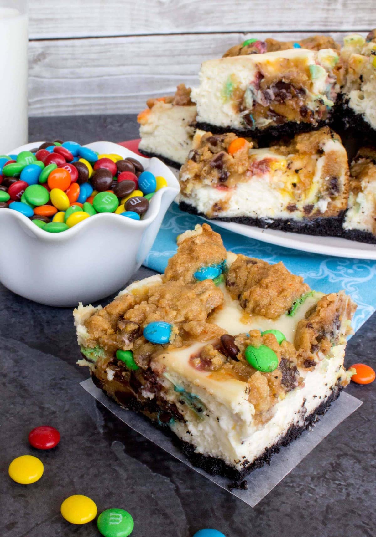 Monster Cookie Cheesecake Square with plate full of squares in background