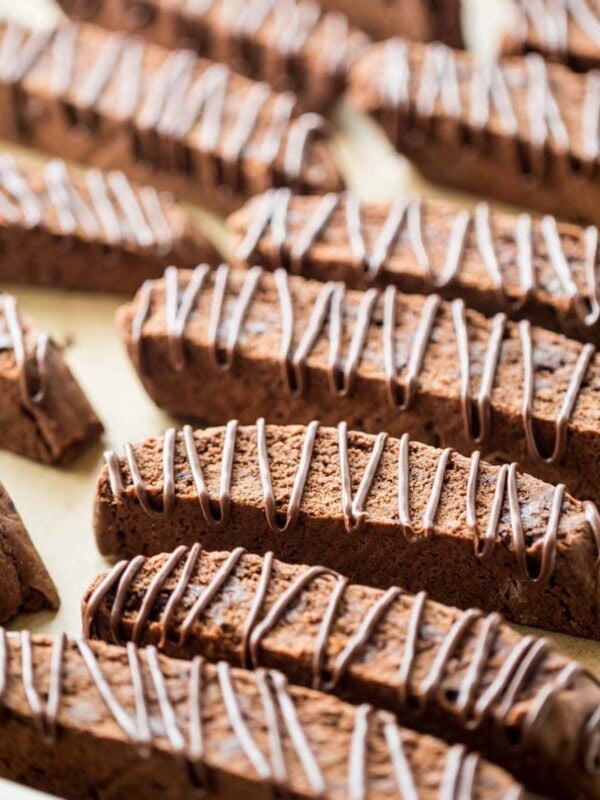 chocolate drizzled chocolate biscotti cookies arranged on a baking sheet