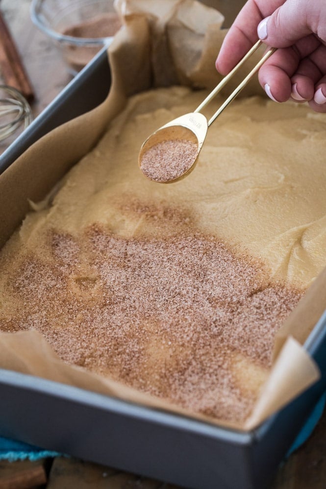 Sprinkling cinnamon and sugar over batter before baking