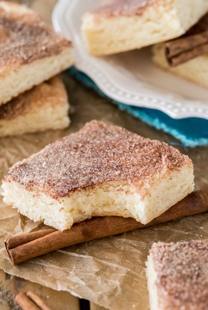 Snickerdoodle cookie bar with bite out of it to show soft chewy center texture