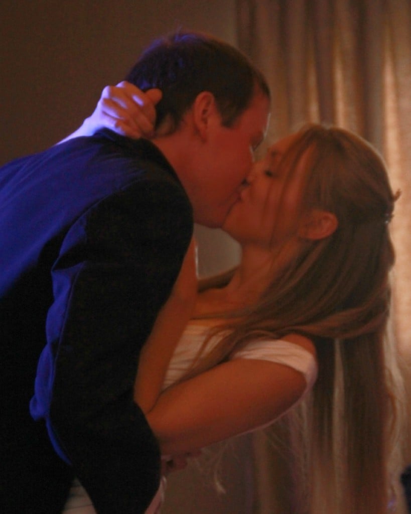 bride and groom kiss while dancing