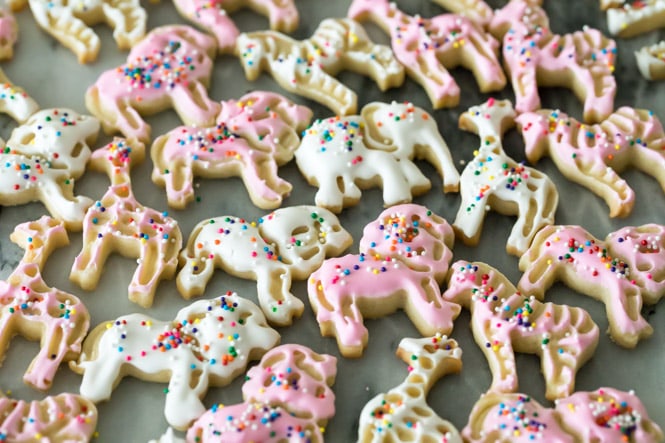 Pink and white frosted animal cookies on marble