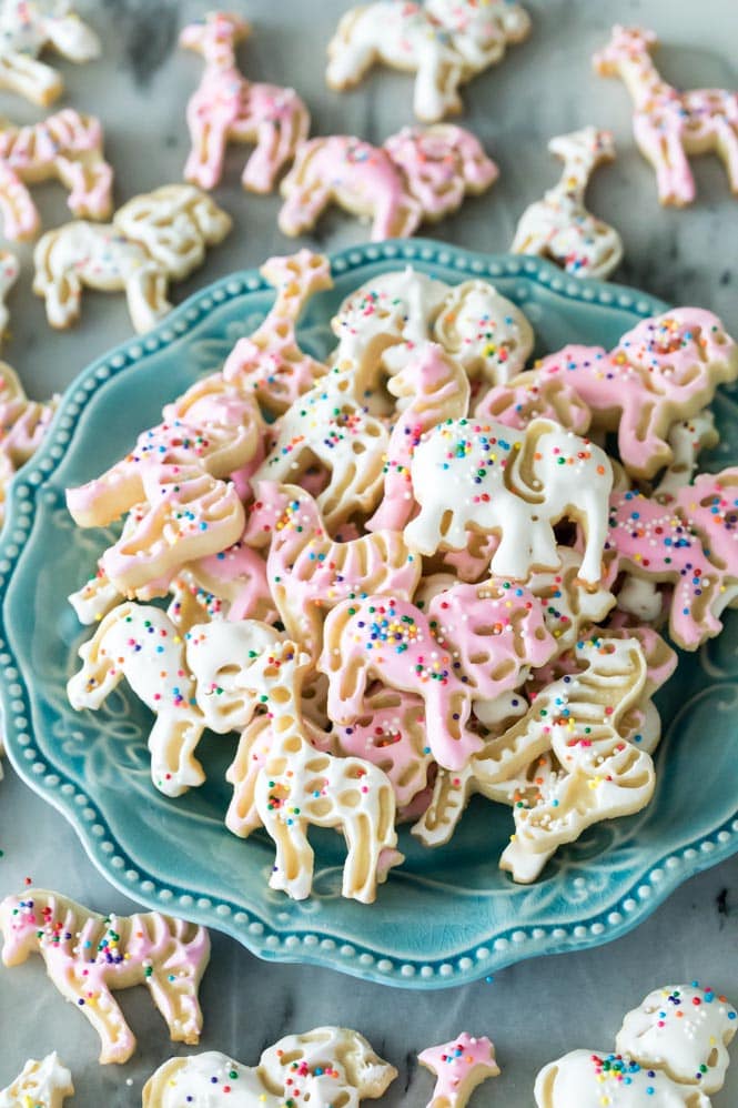 Pink and white frosted animal cookies on a blue plate