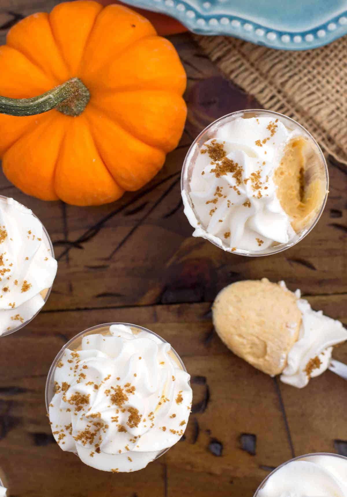 overhead of mini pumpkin pie cheesecake desserts with a bite missing