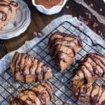 Chocolate scones drizzled with chocolate icing on a cooling rack