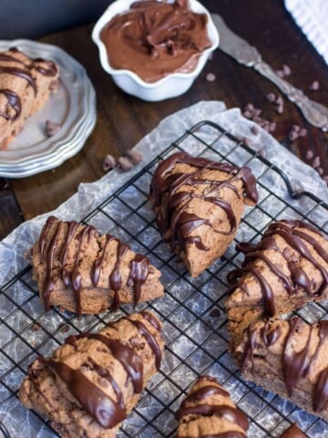Chocolate scones drizzled with chocolate icing on a cooling rack