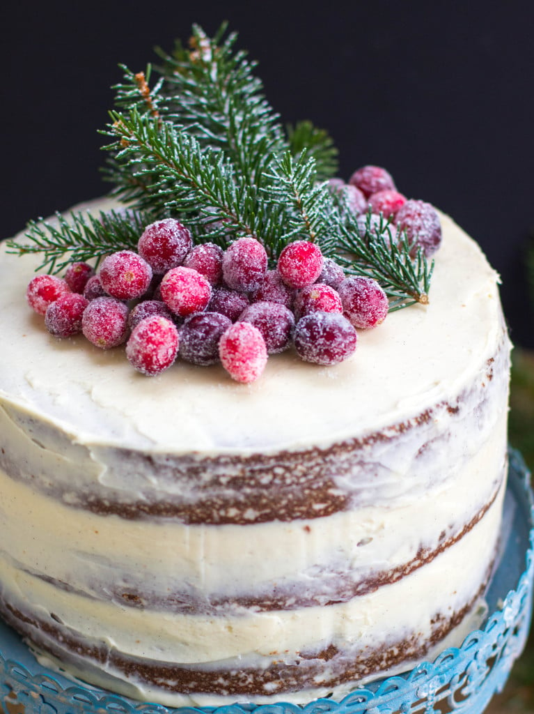 3 layer cake topped with sugared cranberries and pine clippings