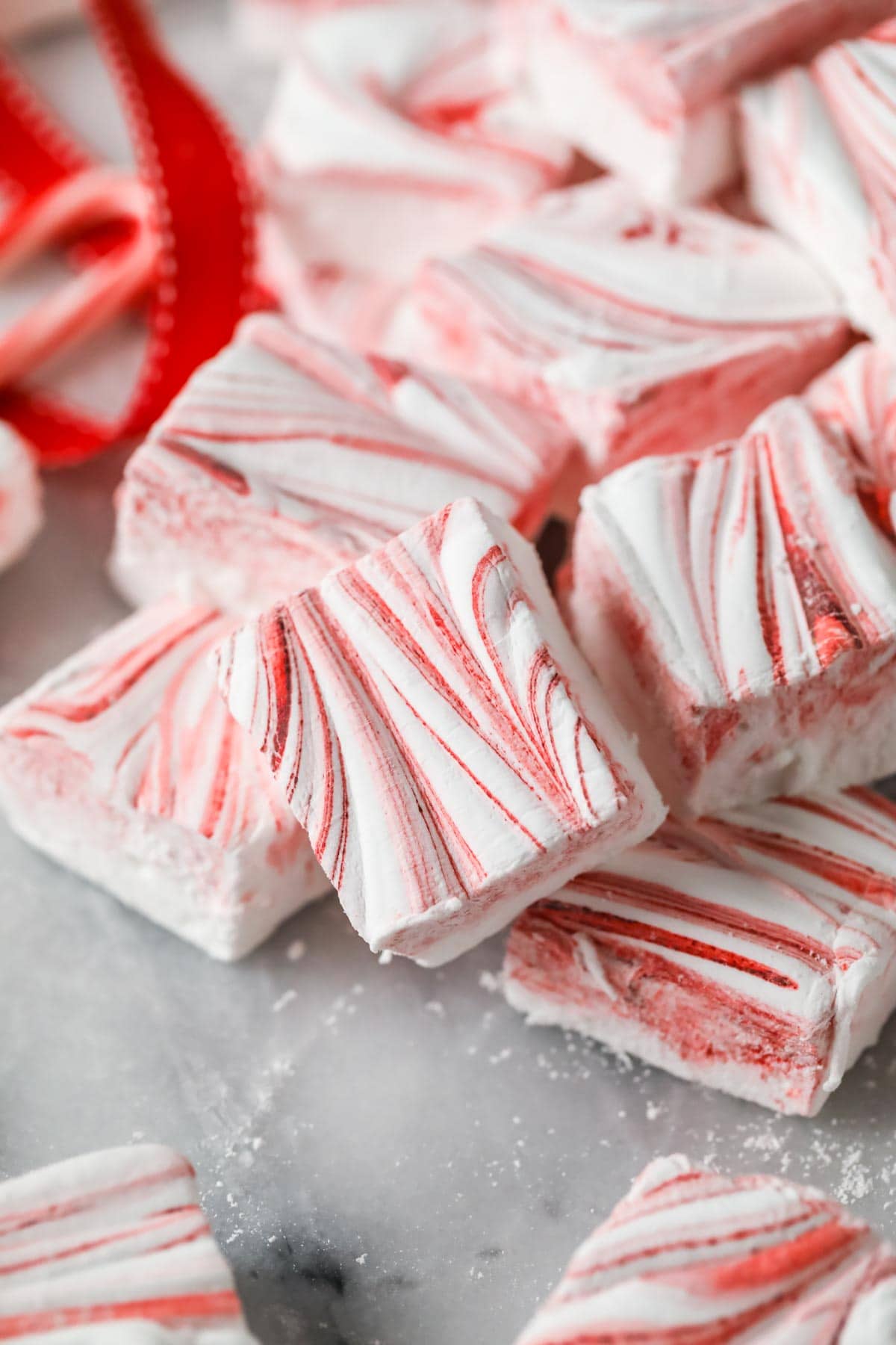 closeup of a red swirled marshmallow with red ribbon in background