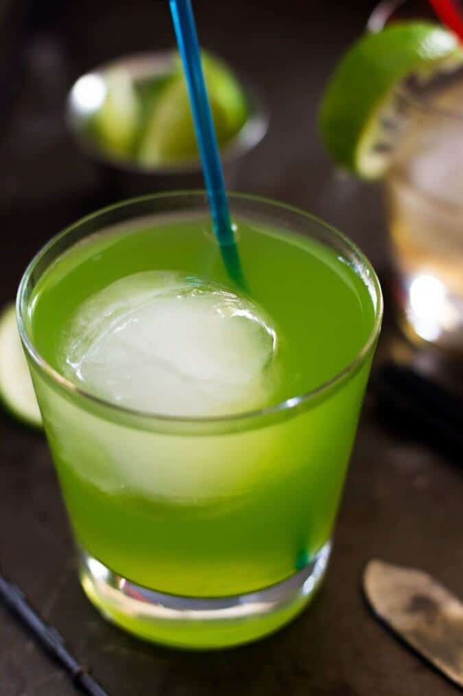 green drink with round ice cube in glass