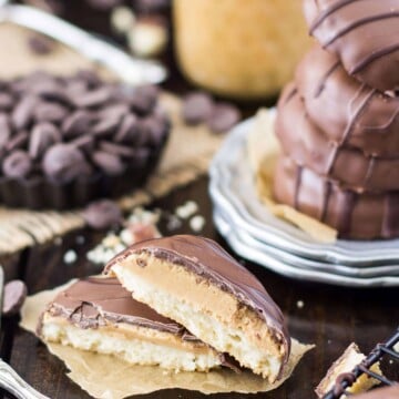 Tagalong cookies broken in half to show the layered cookie, stack of four cookies on a silver plate in the background