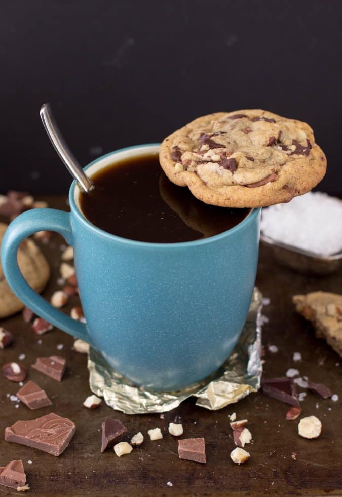 cookie balancing on edge of full coffee mug