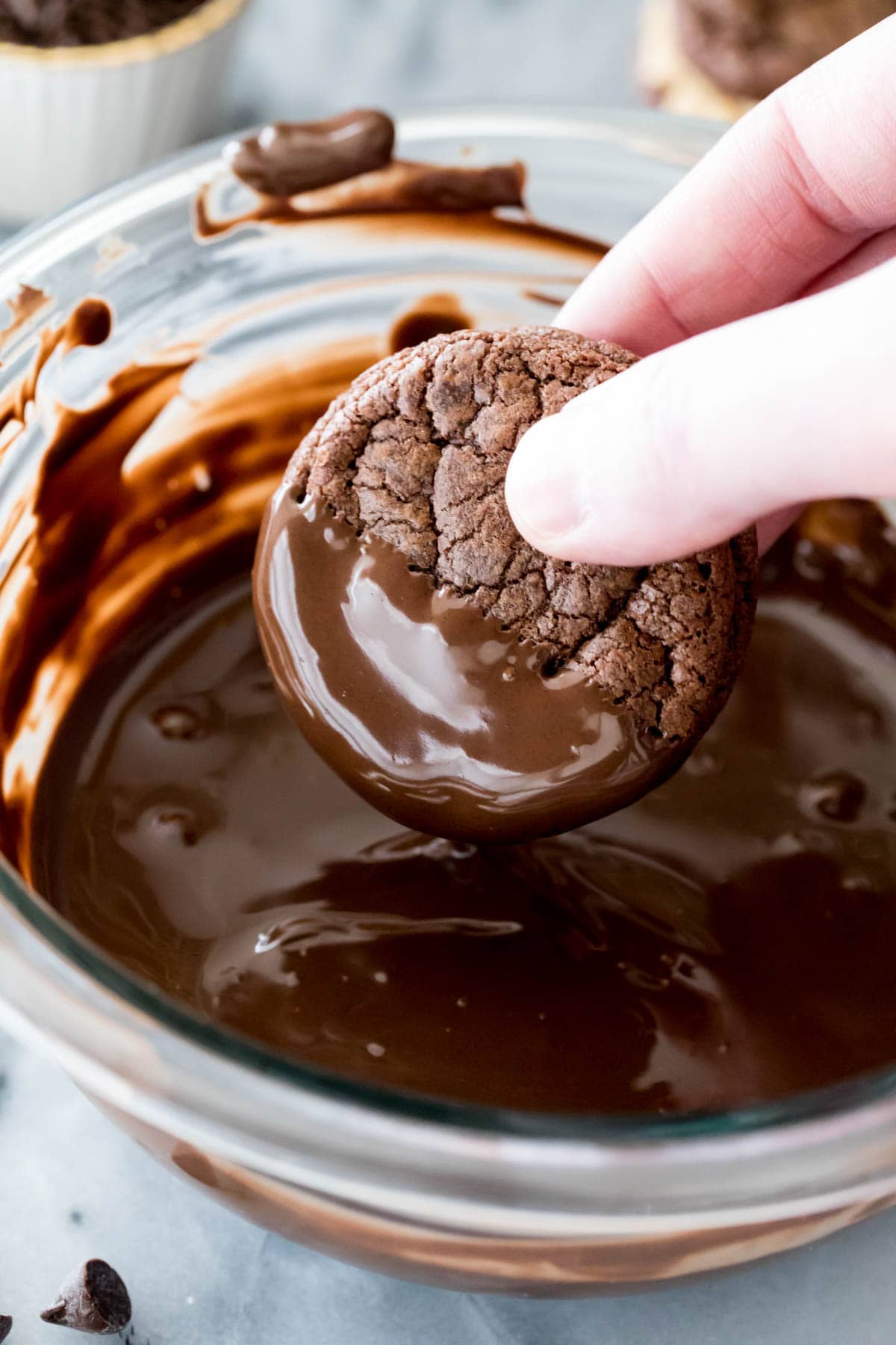 dipping sandwich cookie in melted chocolate