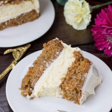 Slice of carrot cake cheesecake on a white plate