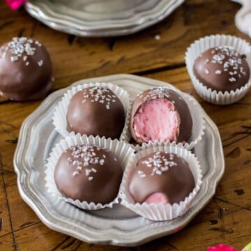 Chocolate covered strawberry buttercream candies on a silver plate