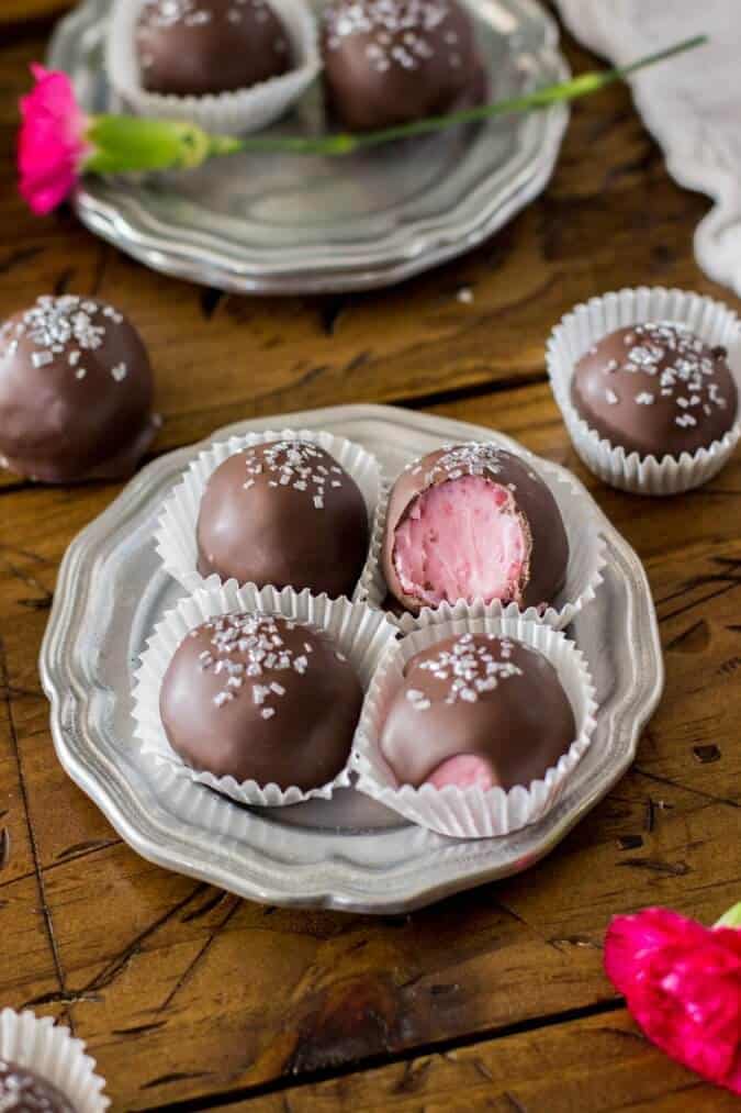 Chocolate covered strawberry buttercream candies on a silver plate