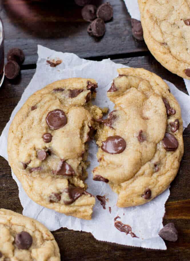 A warm chocolate chip cookie broken in half to show melty center