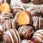 chocolate coated peanut butter ball bitten to show peanut butter center arranged among other decorated balls