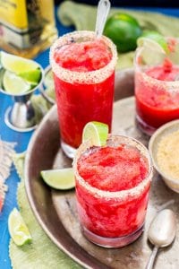 Strawberry margarita granita with a slice of lime, on a silver serving tray