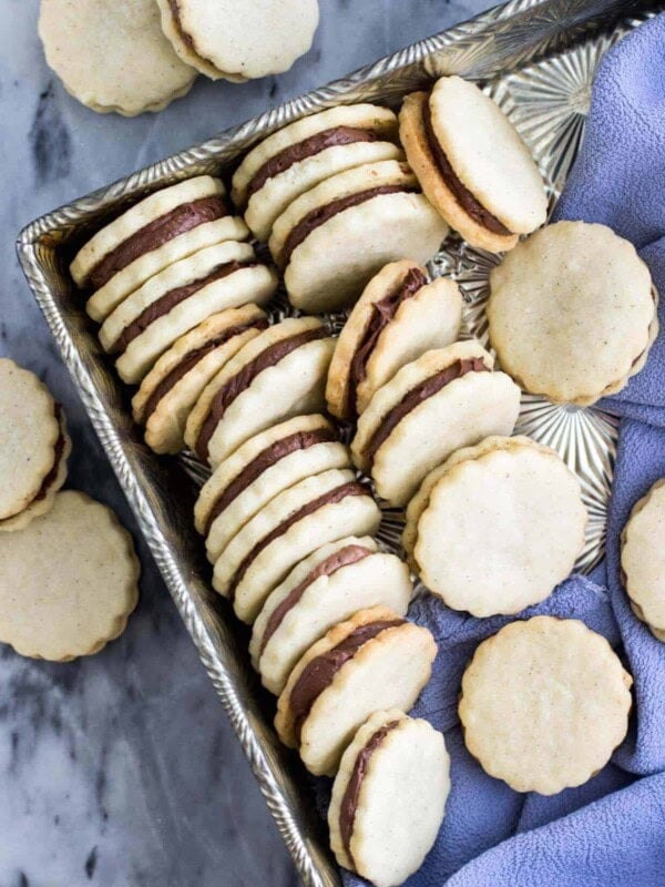Vanilla and chocolate sandwich cookies, lined up in a silver serving tray