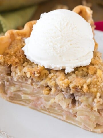 slice of apple pie with ice cream on white plate