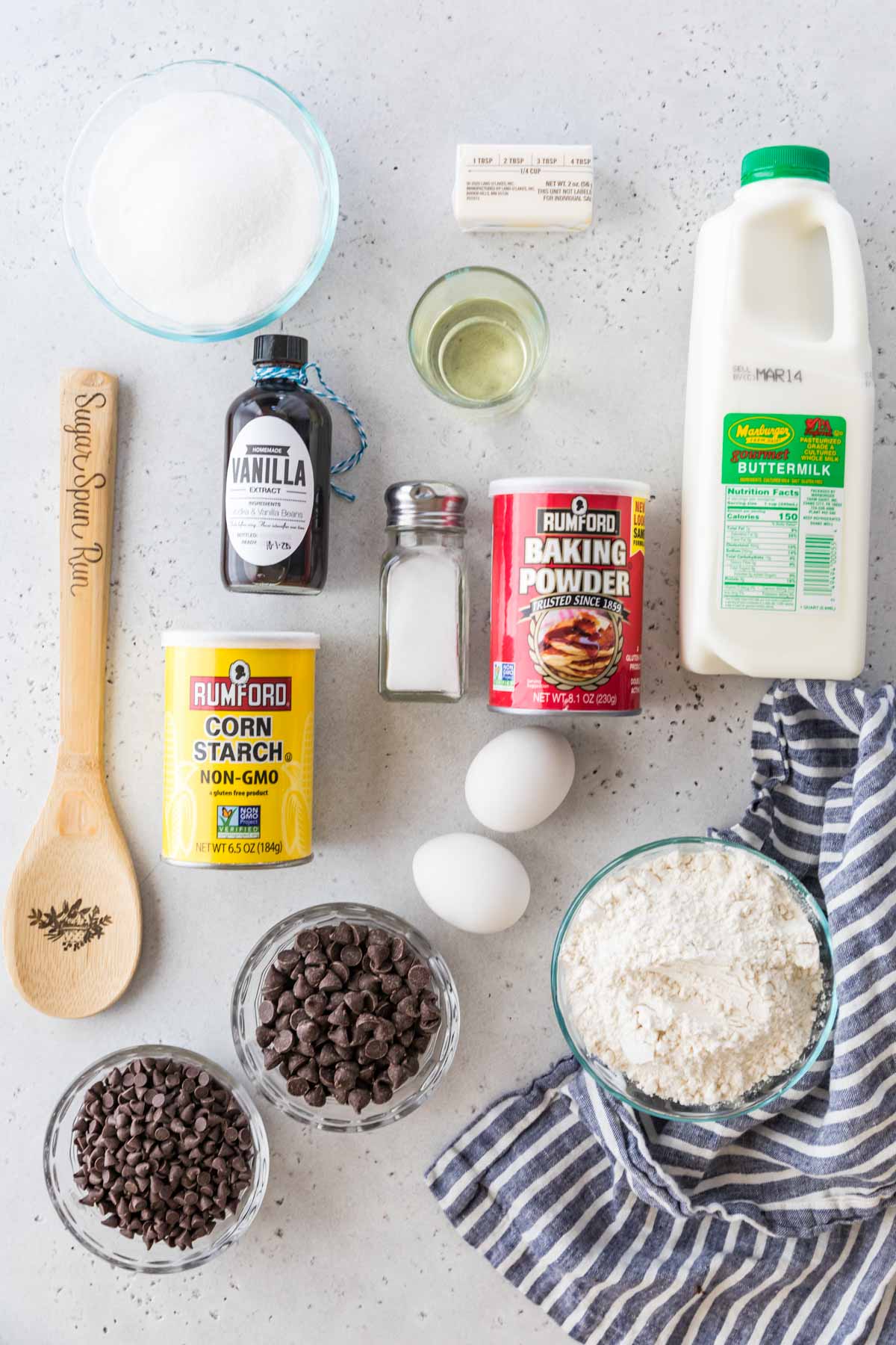 Ingredients needed to make chocolate chip bakery style muffins arranged on a board