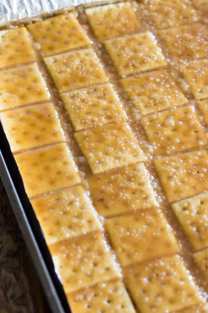 Caramel mix on top of saltine crackers in a baking sheet