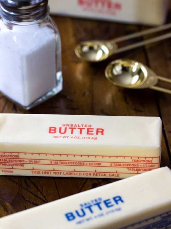 Stick of salted butter, unsalted butter, and a shaker of salt