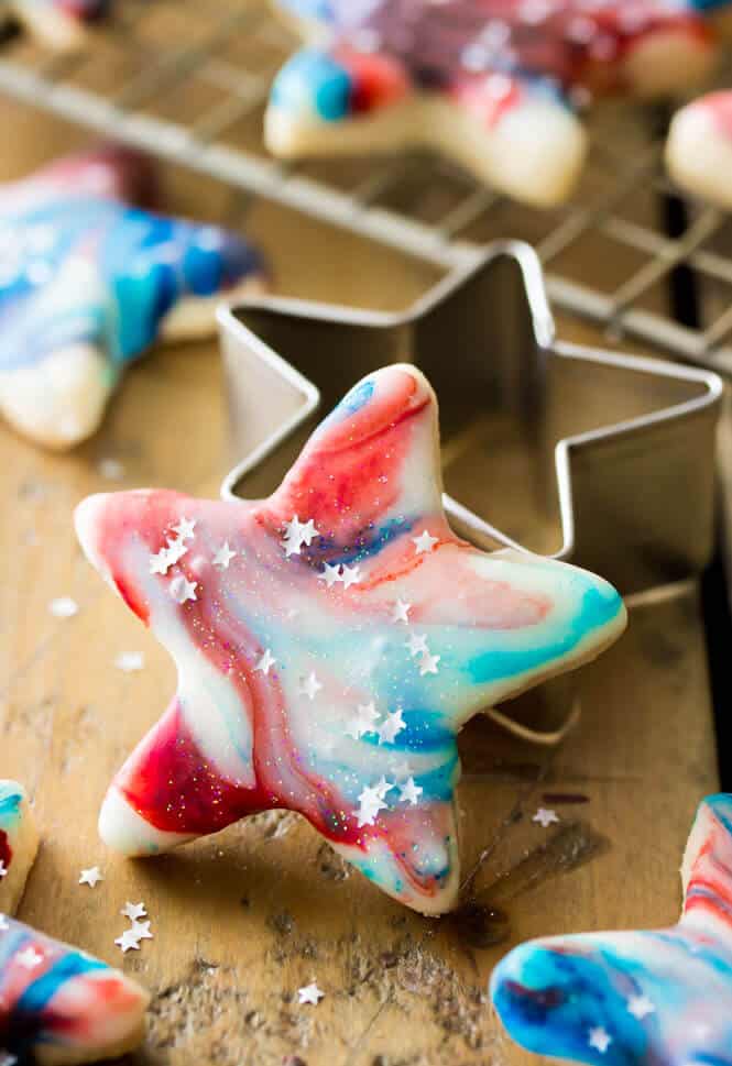 A variety of patriotic and memorial day cookies, including red, white, and blue frosted sugar cookies and chocolate-dipped Oreos, arranged festively.