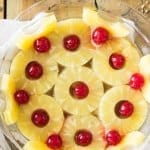 Overhead of pineapples and cherries in glass pie dish