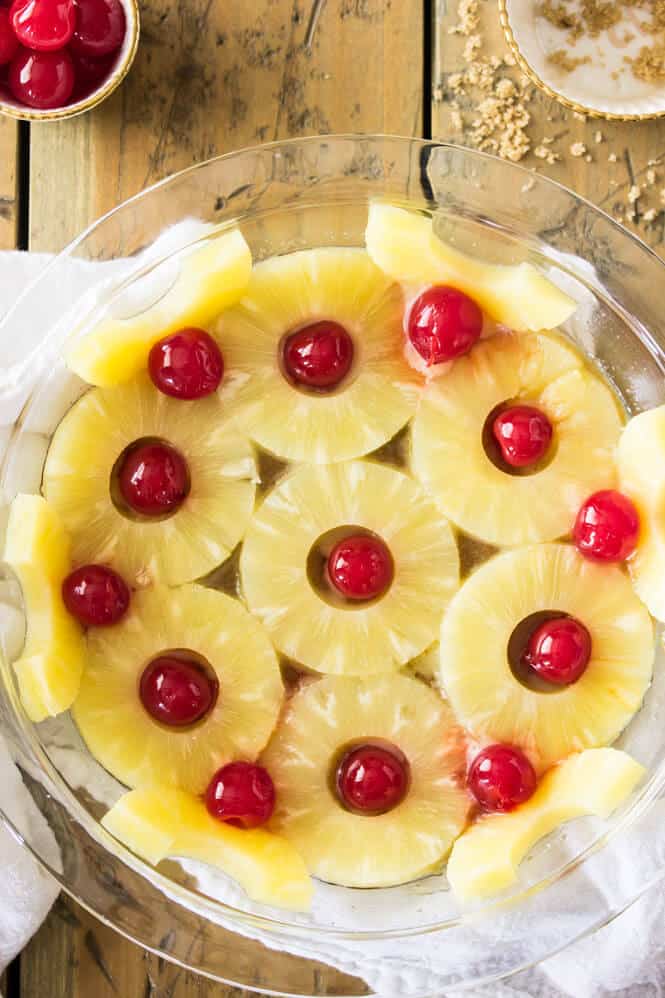 arranging cherries and pineapple rings in a pattern in pie plate