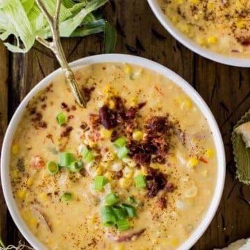 Overhead of corn chowder in bowl with toppings