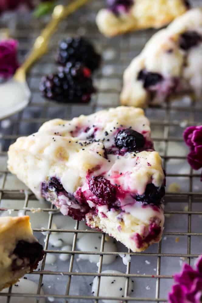 Triple berry scone glazed with icing on cooling rack