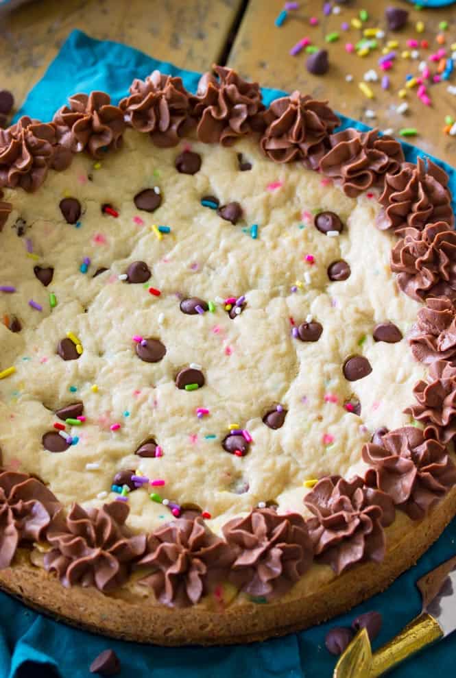 A giant soft baked chocolate chip cookie cake! Complete with sprinkles and chocolate frosting! || Sugar Spun Run