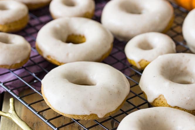 Glazed pumpkin spice donuts on cooling rack