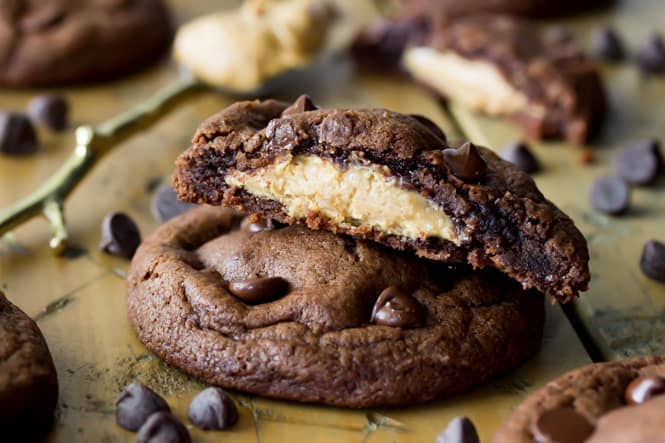 Stack of Peanut Butter Stuffed chocolate chip cookies, broken to see peanut butter filling