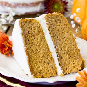 Slice of frosted pumpkin layer cake on plate