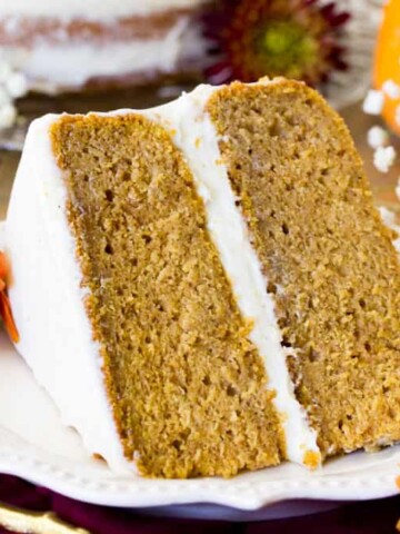 Slice of frosted pumpkin layer cake on plate