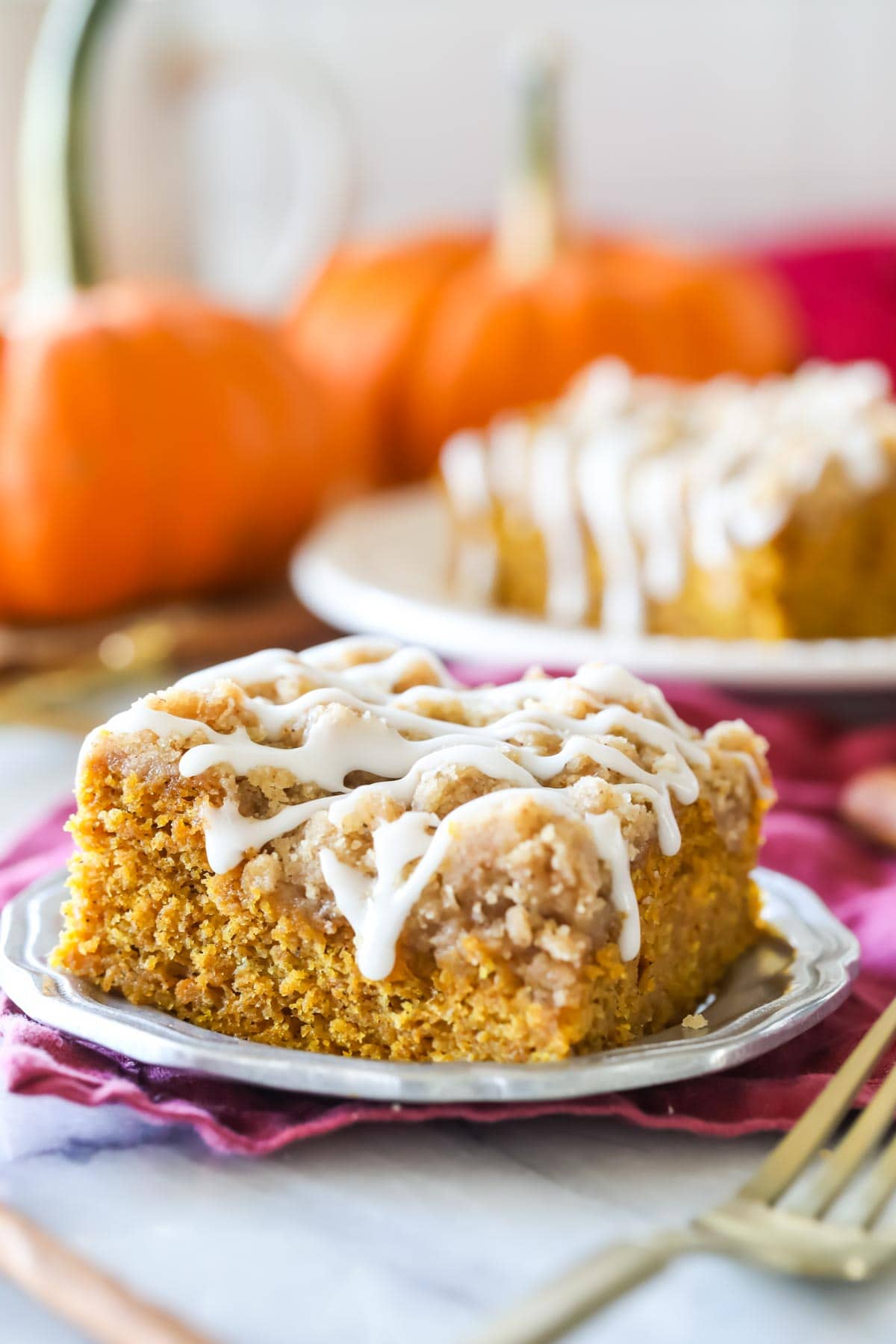 Square of pumpkin coffee cake on silver plate. Drizzled with vanilla glaze.