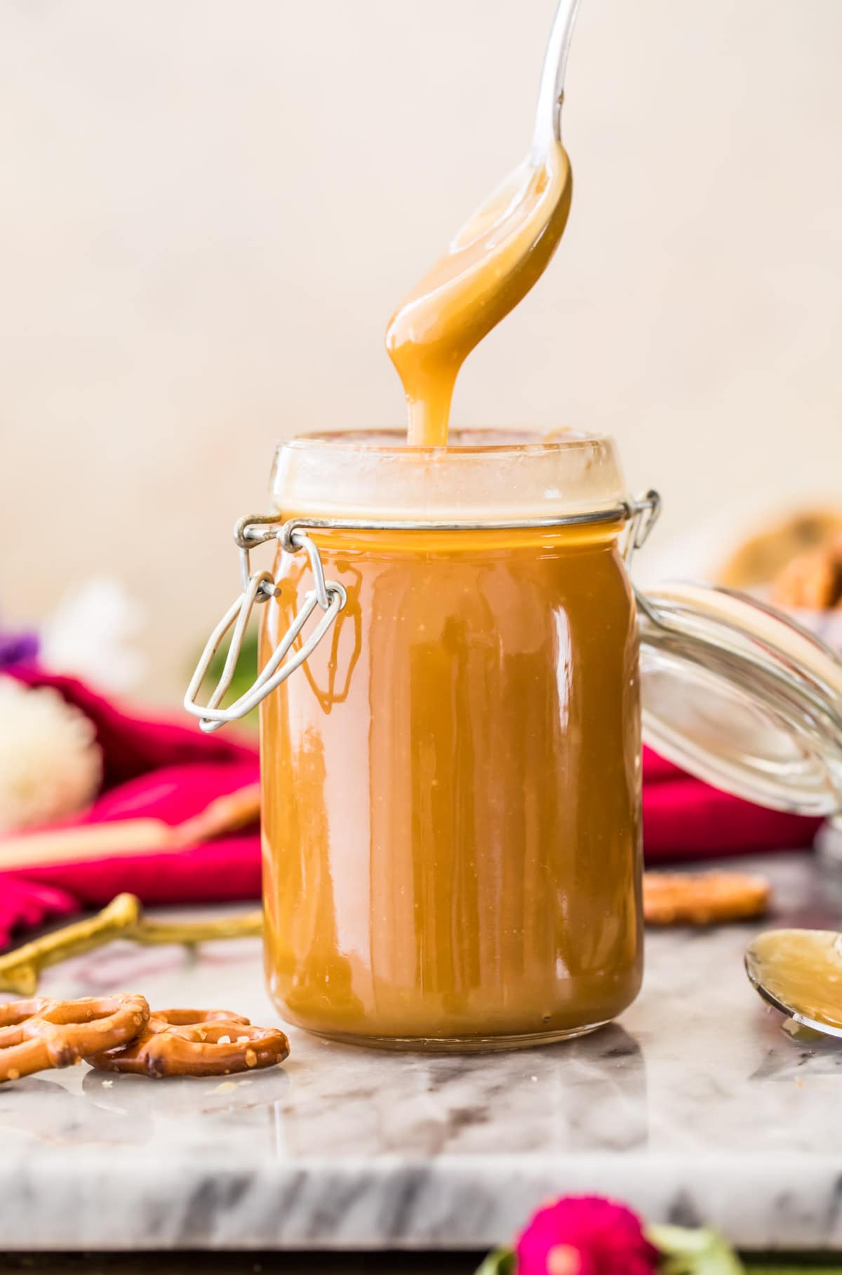 golden caramel sauce dripping off spoon into glass container