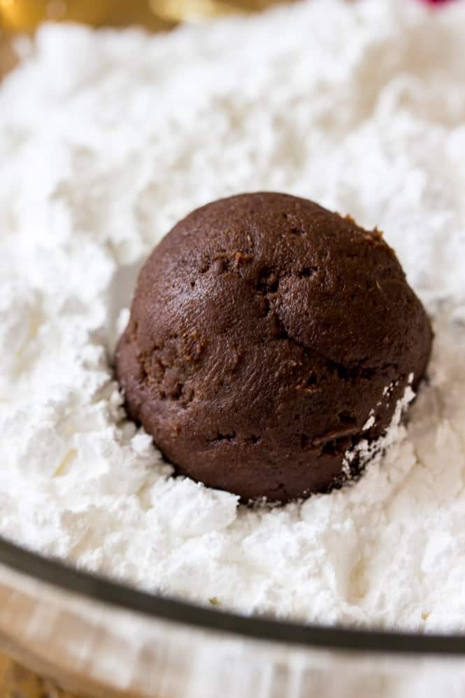 Ball of chocolate crinkle cookie dough rolled through powdered sugar