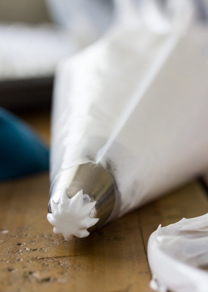 Meringue cookie batter in a piping bag, showing the thick glossy consistency