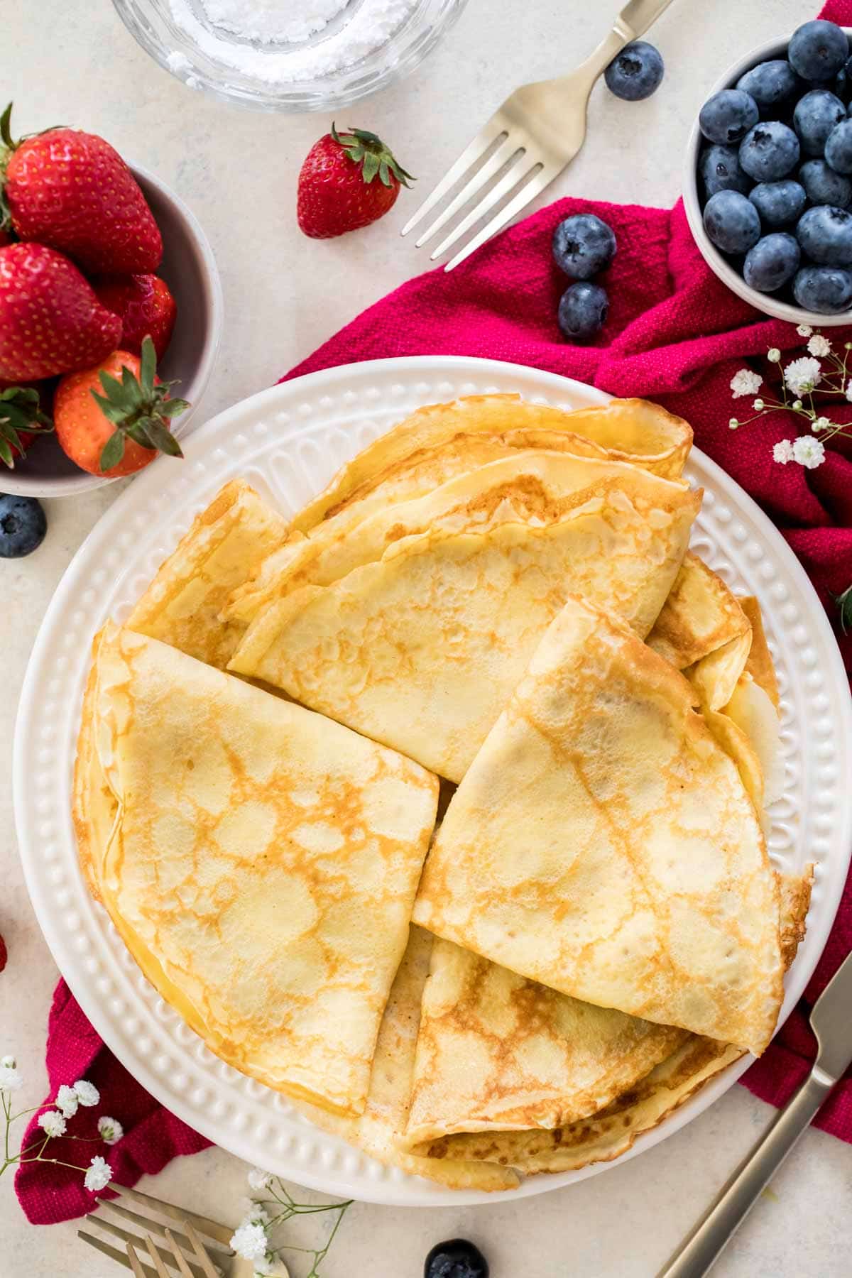 folded crepes on a white plate on a red napkin